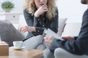Person sitting calmly in a therapy room while discussing mental health support options