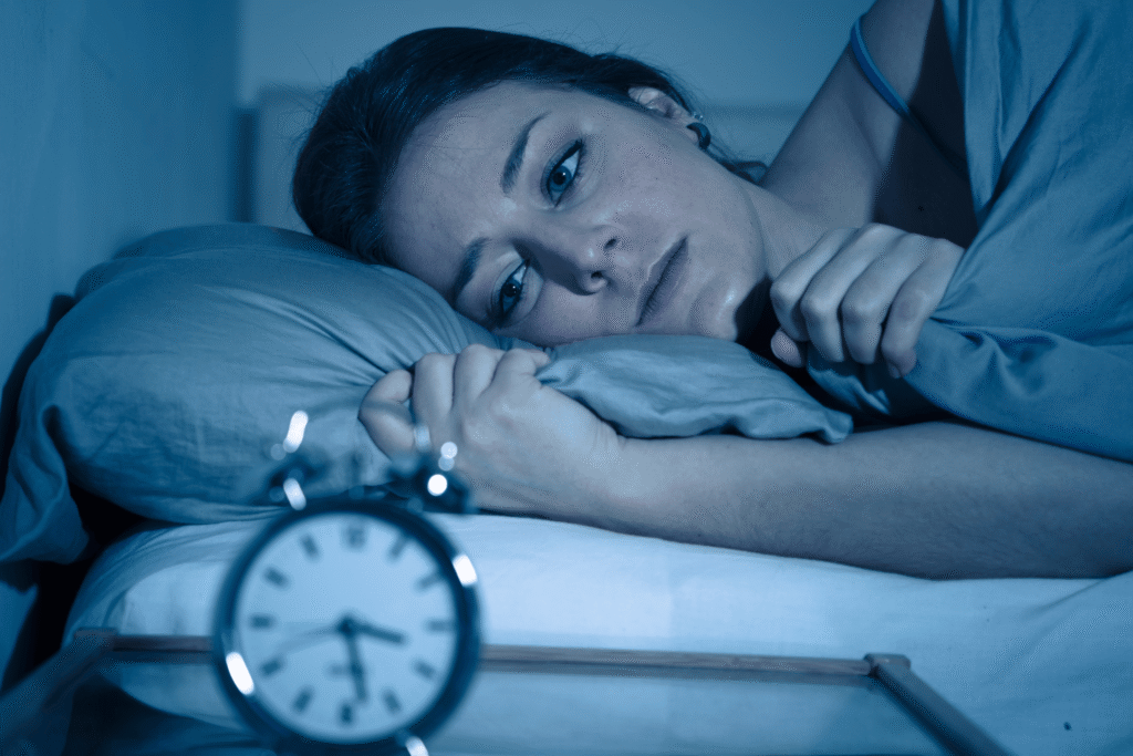 Woman lying awake in bed at night experiencing anxiety and racing thoughts