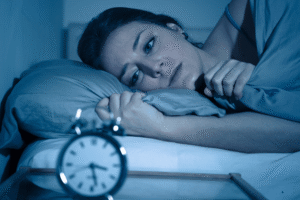 Woman lying awake in bed at night experiencing anxiety and racing thoughts